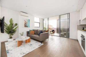 a living room with a couch and a table at Azure Apartments Bondi by Urban Rest in Sydney