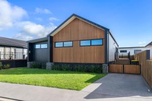 Casa con fachada de madera y patio en The Sun Trap - Waihi Beach Holiday Home, en Waihi Beach