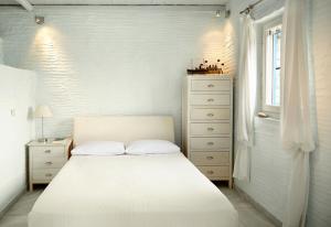 アギオス・イオアニスにあるDinora Villaの白いベッドルーム(白いベッド1台、ドレッサー付)
