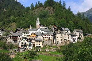 ein großes Dorf auf einem Berg mit einer Kirche in der Unterkunft Antica Osteria Dazio in Fusio