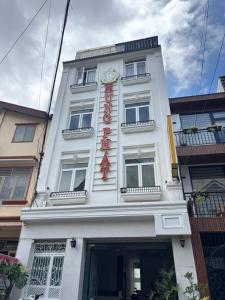 a white building with a sign on it at Hưng Phát Hotel in Da Lat