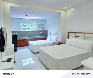 um quarto de hotel com duas camas e uma televisão em EPM Tower Hotel and Events Place em Sampong