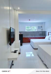 um quarto com duas camas e uma TV de tela plana em EPM Tower Hotel and Events Place em Sampong