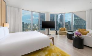 a bedroom with a large white bed and a television at Park Hyatt Bangkok in Bangkok