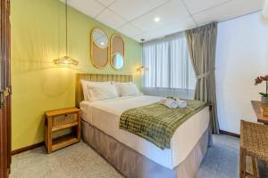 a bedroom with a bed with two towels on it at Casa Lúmina - Hotel Boutique y Spa, San Benito in San Salvador +22 photos