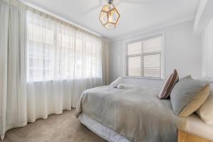 Un dormitorio blanco con una cama y una ventana. en Central Art Deco #5, en Picton