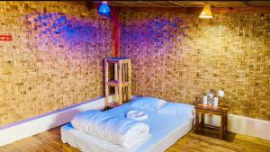 a bed in a room with a brick wall at Giri Raj Resort Bandarban in Bāndarban