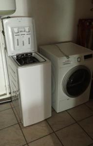 a washer and dryer next to a washing machine at Appartement spacieux de plain pied in Eugénie-les-Bains