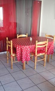a table with a red and white polka dot table cloth at Appartement spacieux de plain pied in Eugénie-les-Bains