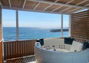 a bath tub on a balcony with the ocean at プチリゾート・ひじきwest in Hijiki