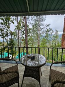 a patio with a table and chairs on a balcony at Whispering Pine Villa in Lansdowne