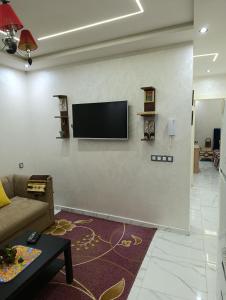 ein Wohnzimmer mit einem Flachbildfernseher an der Wand in der Unterkunft Martil, Tetuán Apartamento in Martil