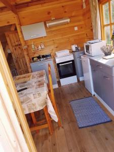 a kitchen with a stove and a table in a cabin at Chalet chaleureux - Ecureuil in Maisod