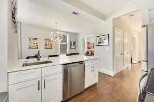 a kitchen with white cabinets and a sink and a refrigerator at Massive Mid-Century Marvel 5 Bedrooms and Parking in Washington