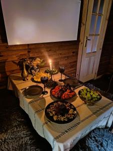 a table with plates of food and a candle on it at VerLema House 46 in Augustów