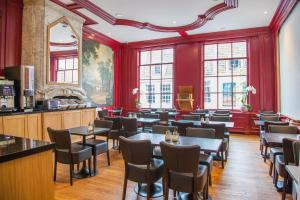 un ristorante con tavoli e sedie in una stanza con pareti rosse di Hotel Library Amsterdam ad Amsterdam