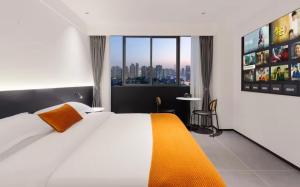 a hotel room with a bed and a view of a city at Enji M Hotel (Guanyinqiao Branch) in Chongqing