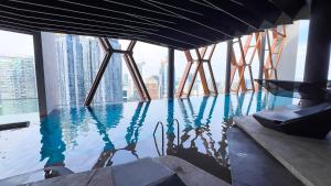 クアラルンプールにあるScarletz Suite KLCC by Light House 1の高層ビルの床に建つインフィニティプール