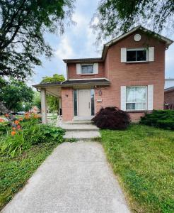 a brick house with a pathway in front of it at Three Bedrooms House in Mississauga with free parking Conveniently located with easy access to the airport downtown Toronto major malls and highways for a seamless stay in Mississauga