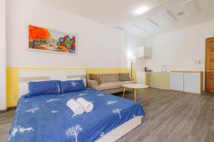 Un dormitorio con una cama azul y un sofá. en NEWROOM-1km 2 Bui Vien, en Ho Chi Minh