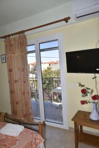 a bedroom with a sliding glass door with a balcony at Summer Dream in Anaxos