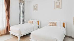 two beds in a room with white walls at Wana Villa ChaAM in Nikhom Sang Ton Eng Khuan Phet +33 photos