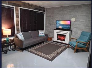 a living room with a couch and a tv and a fireplace at The Reel Freedom Cottage at Leesville Lake in Carrollton