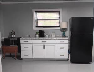 a kitchen with white cabinets and a black refrigerator at The Reel Freedom Cottage at Leesville Lake in Carrollton +25 photos