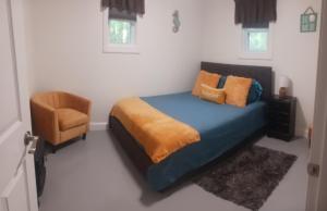 a bedroom with a blue bed and a chair at The Reel Freedom Cottage at Leesville Lake in Carrollton