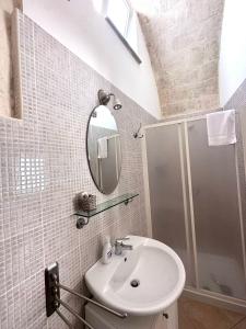 a bathroom with a sink and a shower and a mirror at Agorà nei sassi in Matera