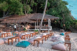 a beach with chairs and tables and a hut at SeaTara Resort in Ko Phangan