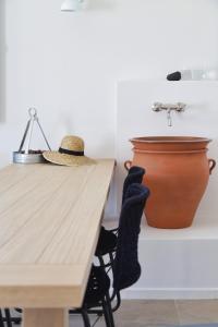 un sombrero sentado en una mesa junto a un fregadero en Vino Houses, en Oia