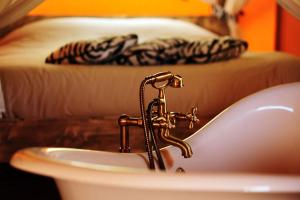 a bathroom sink with a gold faucet and a sink at Kimaro Farmhouse in Colméry +36 photos