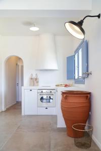 a kitchen with blue and white cabinets and a pot at Vino Houses in Oia