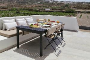 a table with a plate of food on a balcony at Vino Houses Santorini in Oia