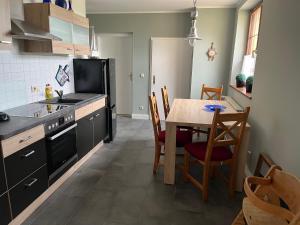 a kitchen with a table and a black refrigerator at Ferienwohnung Heiligenhagen in Satow