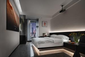 a bedroom with a large white bed and a table at Enji M Hotel-Chongqing Shapingba High-speed Railway Station Three Gorges Square in Chongqing