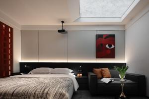 a bedroom with a large bed and a couch at Enji M Hotel-Chongqing Shapingba High-speed Railway Station Three Gorges Square in Chongqing