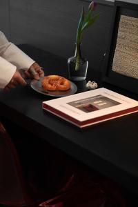 a table with a plate of donuts and a book at Enji M Hotel-Chongqing Shapingba High-speed Railway Station Three Gorges Square in Chongqing