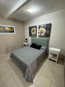 ein Schlafzimmer mit einem Bett und zwei Bildern an der Wand in der Unterkunft Apart Suipacha in Río Cuarto