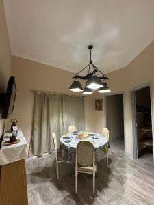 einen Esstisch mit Stühlen und einem Kronleuchter in der Unterkunft Apart Suipacha in Río Cuarto