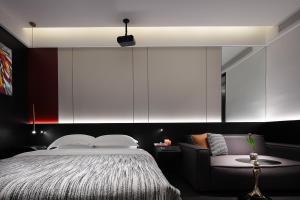 a bedroom with a large bed and a couch at Enji M Hotel-Chongqing Shapingba High-speed Railway Station Three Gorges Square in Chongqing