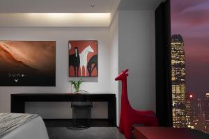 a bedroom with a red chair and a painting on the wall at Enji M Hotel-Chongqing Shapingba High-speed Railway Station Three Gorges Square in Chongqing