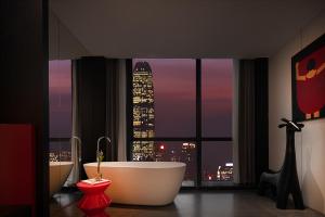 a bathroom with a tub and a view of a city skyline at Enji M Hotel-Chongqing Shapingba High-speed Railway Station Three Gorges Square in Chongqing