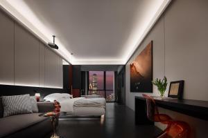 a bedroom with a bed and a couch and a table at Enji M Hotel-Chongqing Shapingba High-speed Railway Station Three Gorges Square in Chongqing