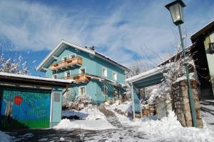 ein blaues Haus im Schnee mit Straßenlicht in der Unterkunft Atelierwohnung Jirana in Saalfelden am Steinernen Meer