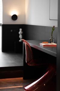 a red chair sitting in front of a black counter top at Enji M Hotel-Chongqing Shapingba High-speed Railway Station Three Gorges Square in Chongqing
