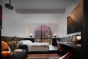 a bedroom with a bed and a view of a city at Enji M Hotel-Chongqing Shapingba High-speed Railway Station Three Gorges Square in Chongqing
