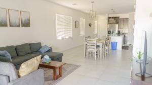 a living room with a couch and a kitchen at Spacious 3BR Home - Pool, Playground, EV Station L2, Near Freeway, Free Parking in Tucson