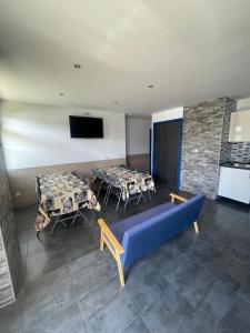 Pokój z dwoma stołami i niebieską kanapą w obiekcie Hego Haize Zarautz Hostel w mieście Zarautz